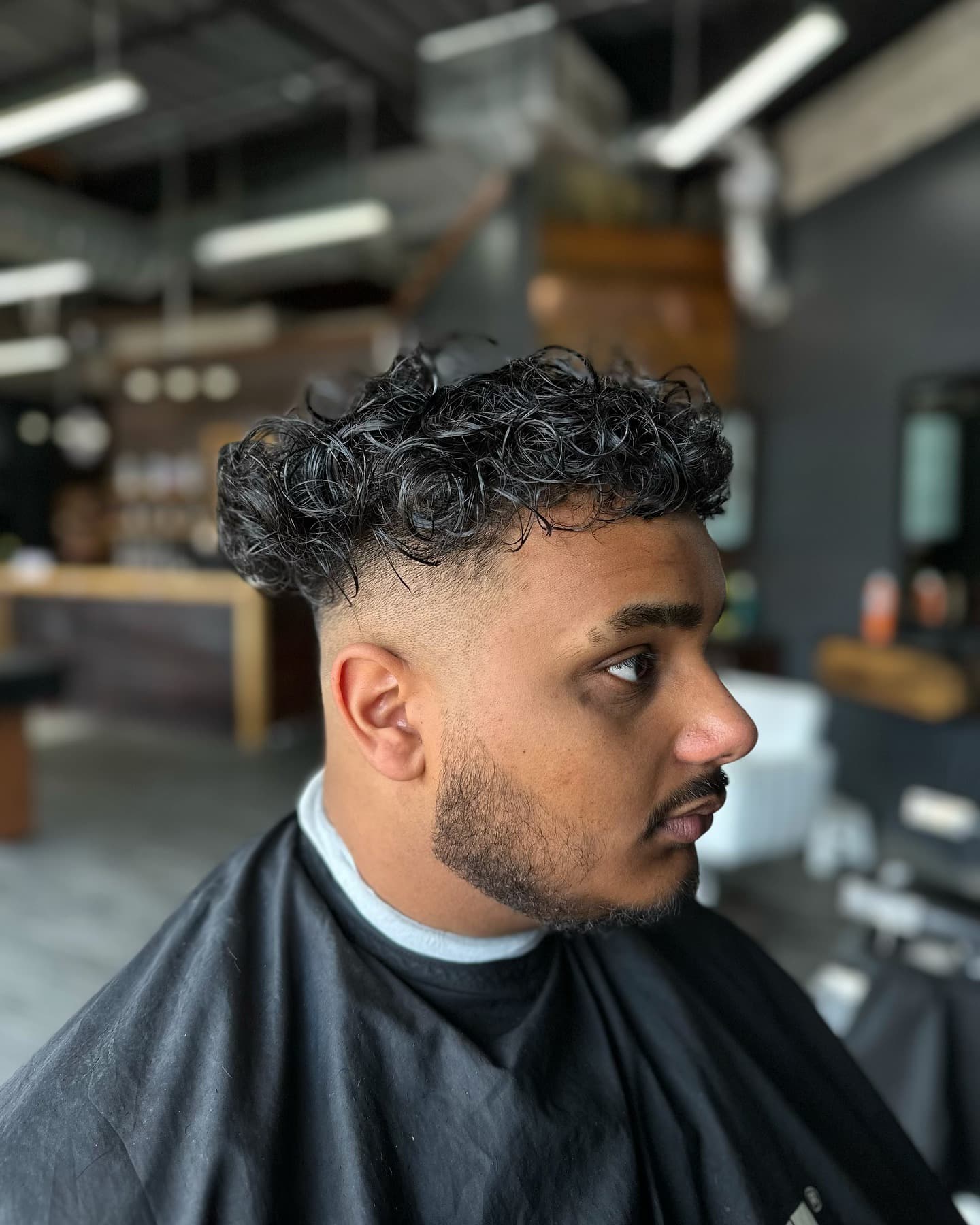 High fade with curly top by Rahiem
